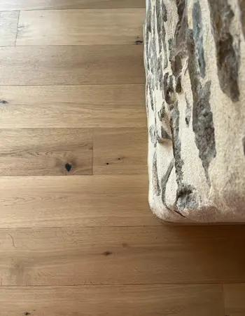 finition parquet avec un angle de mur en pierres