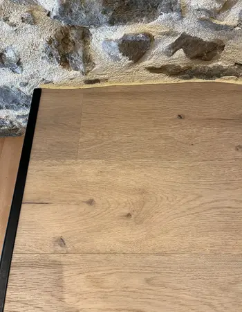 finition parquet avec mur en pierres